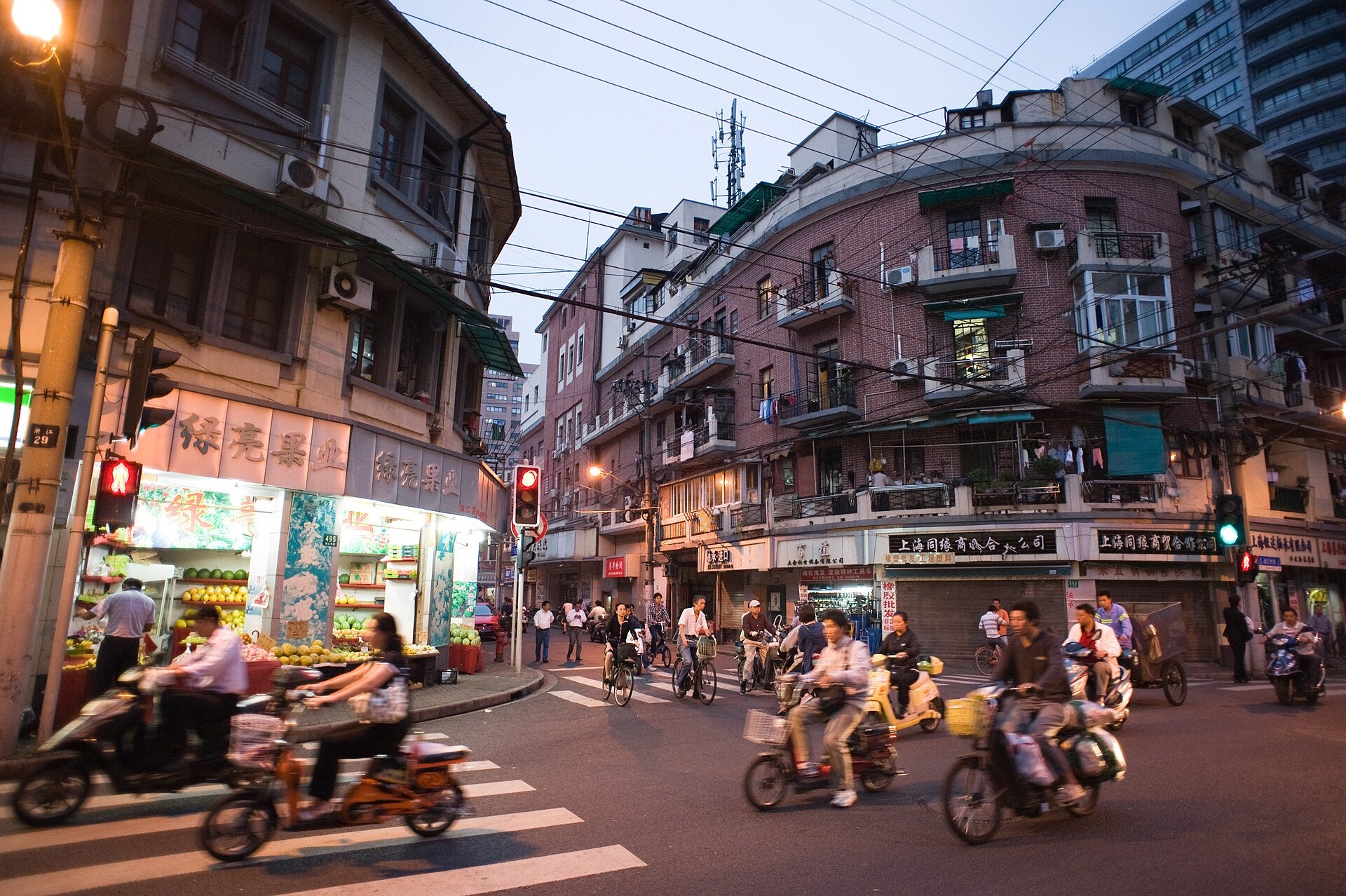 A lived-in Shanghai neighbourhood street moving from dusk into night