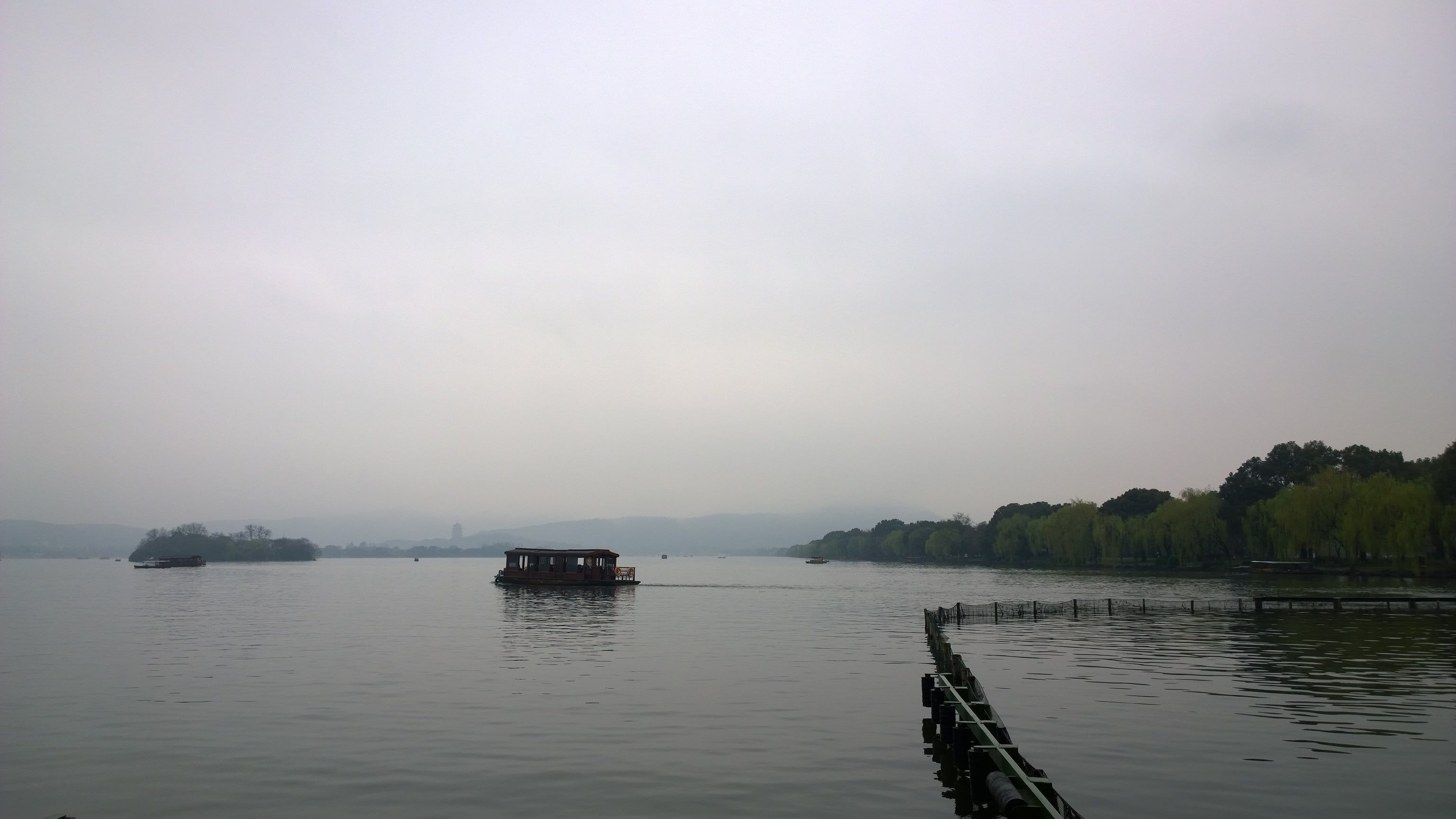 A boat crossing West Lake in Hangzhou, seen from the water-level landscape