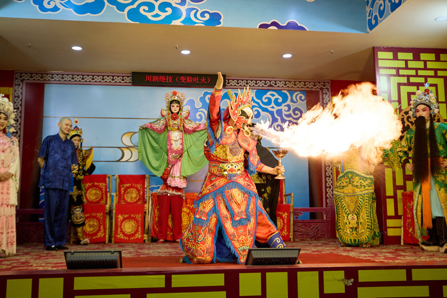 A Sichuan opera performer breathing fire on stage.