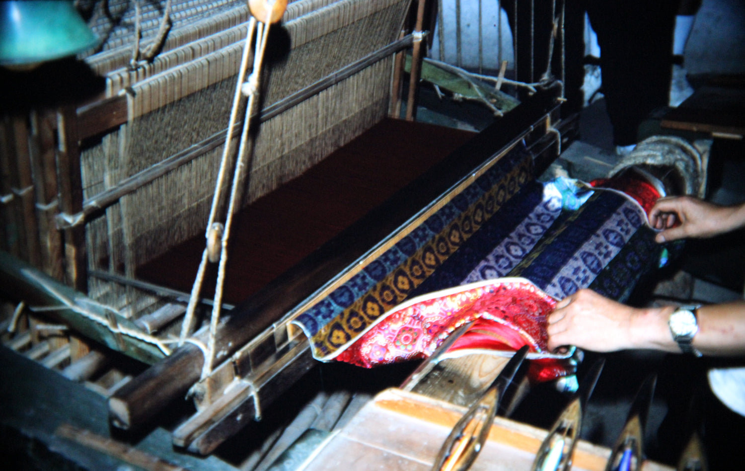 Hands operating a silk loom with patterned Shu brocade in a Chengdu factory