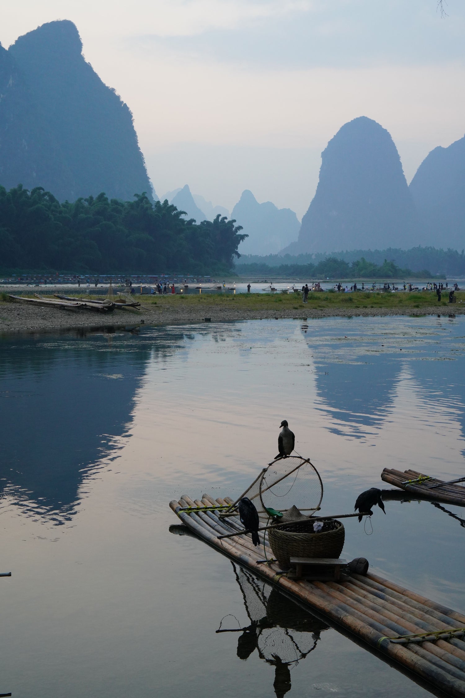Bamboo rafts and cormorants on a river beneath Guilin karst peaks.