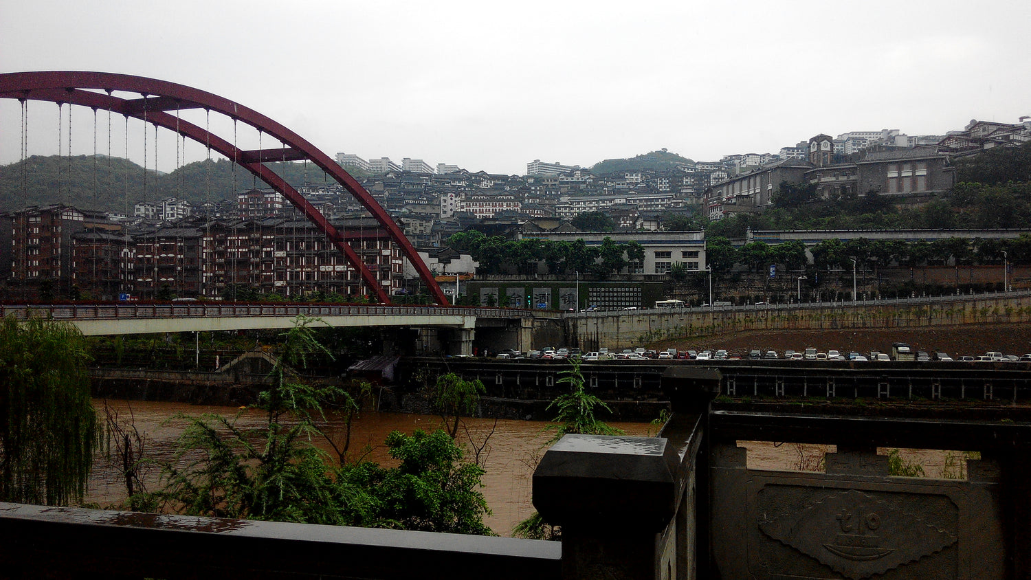 Red bridge and hillside buildings along the Chishui River in Maotai town, Guizhou.