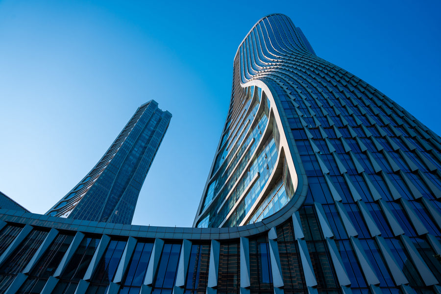 Modern glass buildings in Hangzhou under a clear blue sky.