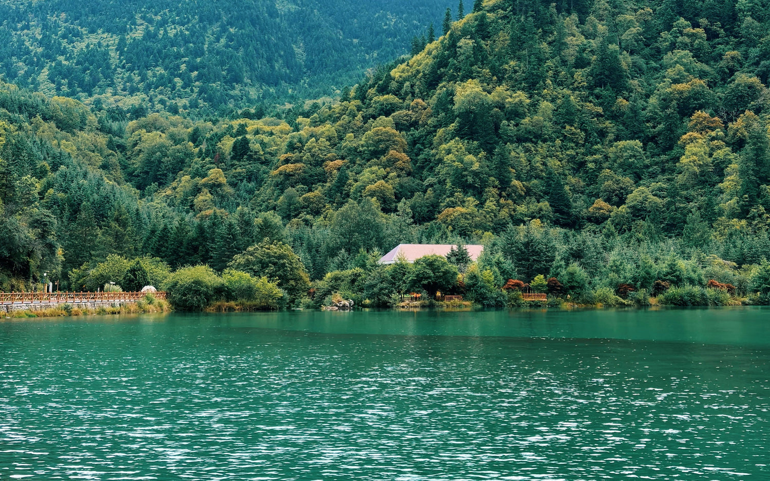 Emerald water and forested mountains in Jiuzhaigou Valley, Sichuan.