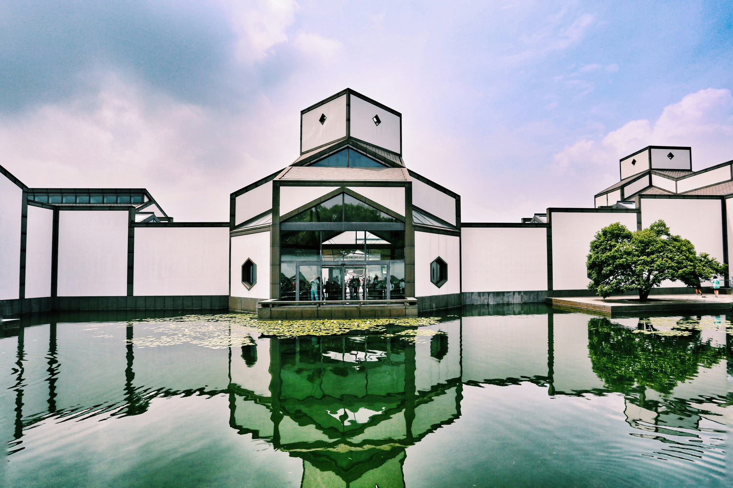 The white-and-charcoal geometry of Suzhou Museum reflected in its entrance pool.