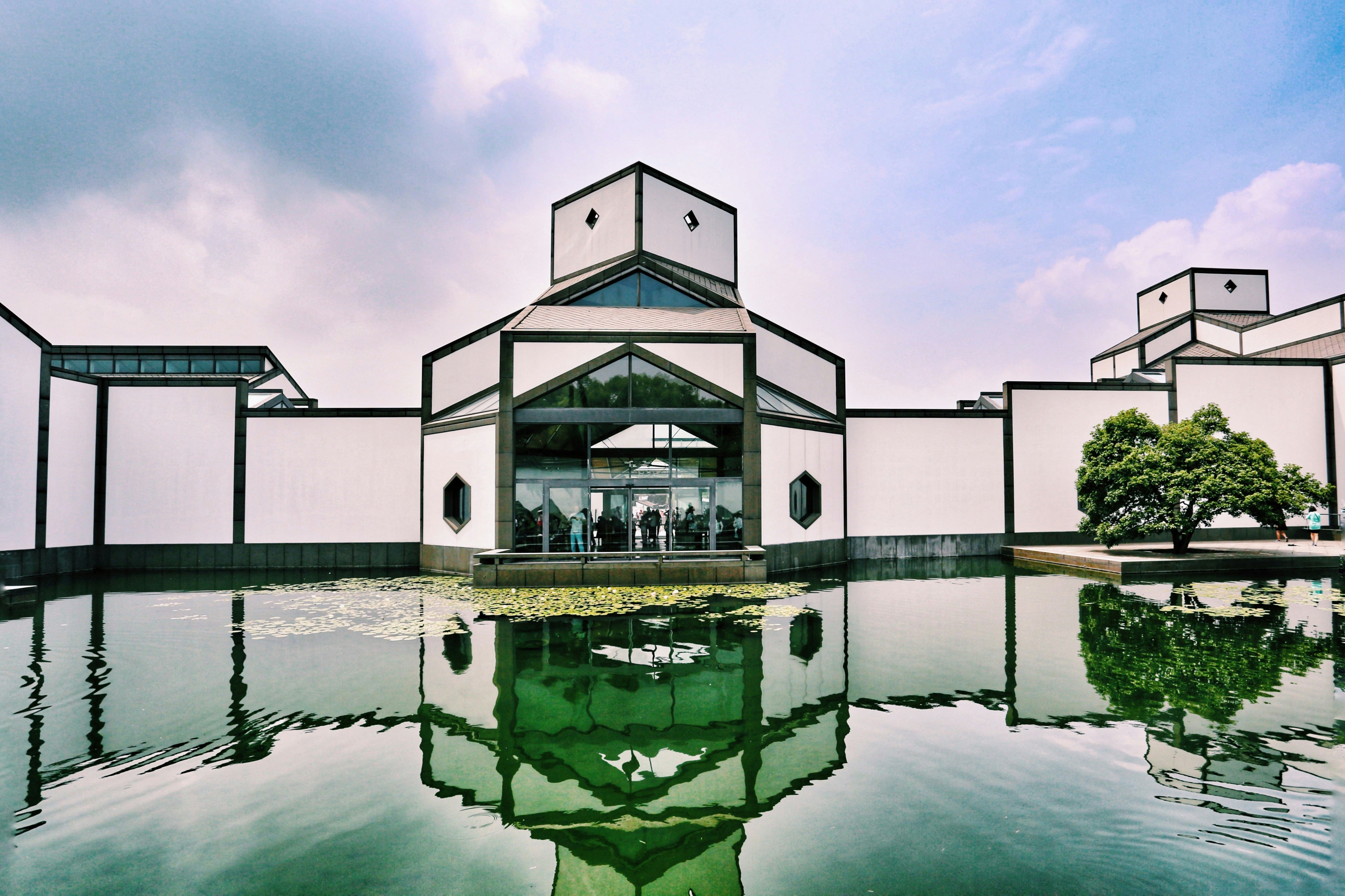 The white-and-charcoal geometry of Suzhou Museum reflected in its entrance pool.