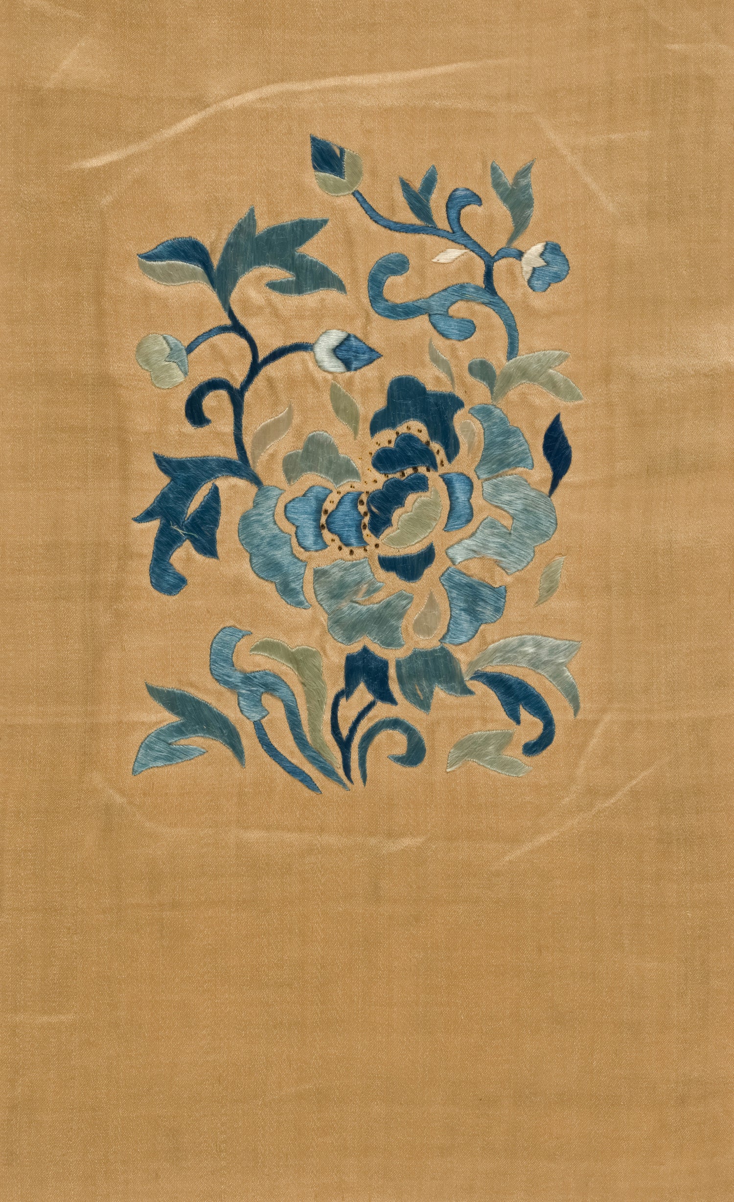Blue floral Chinese embroidery on a tan silk textile fragment.