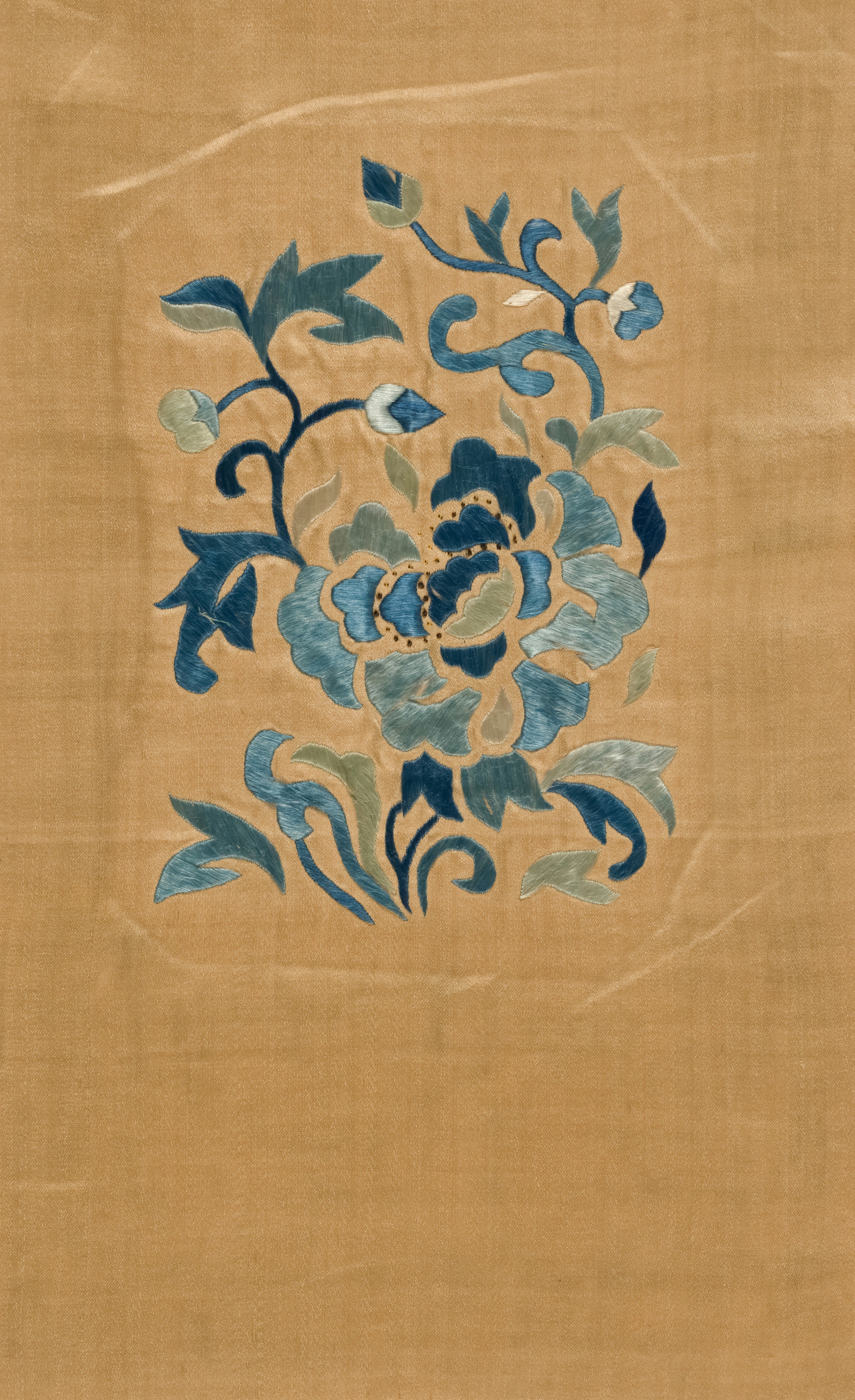 Blue floral Chinese embroidery on a tan silk textile fragment.