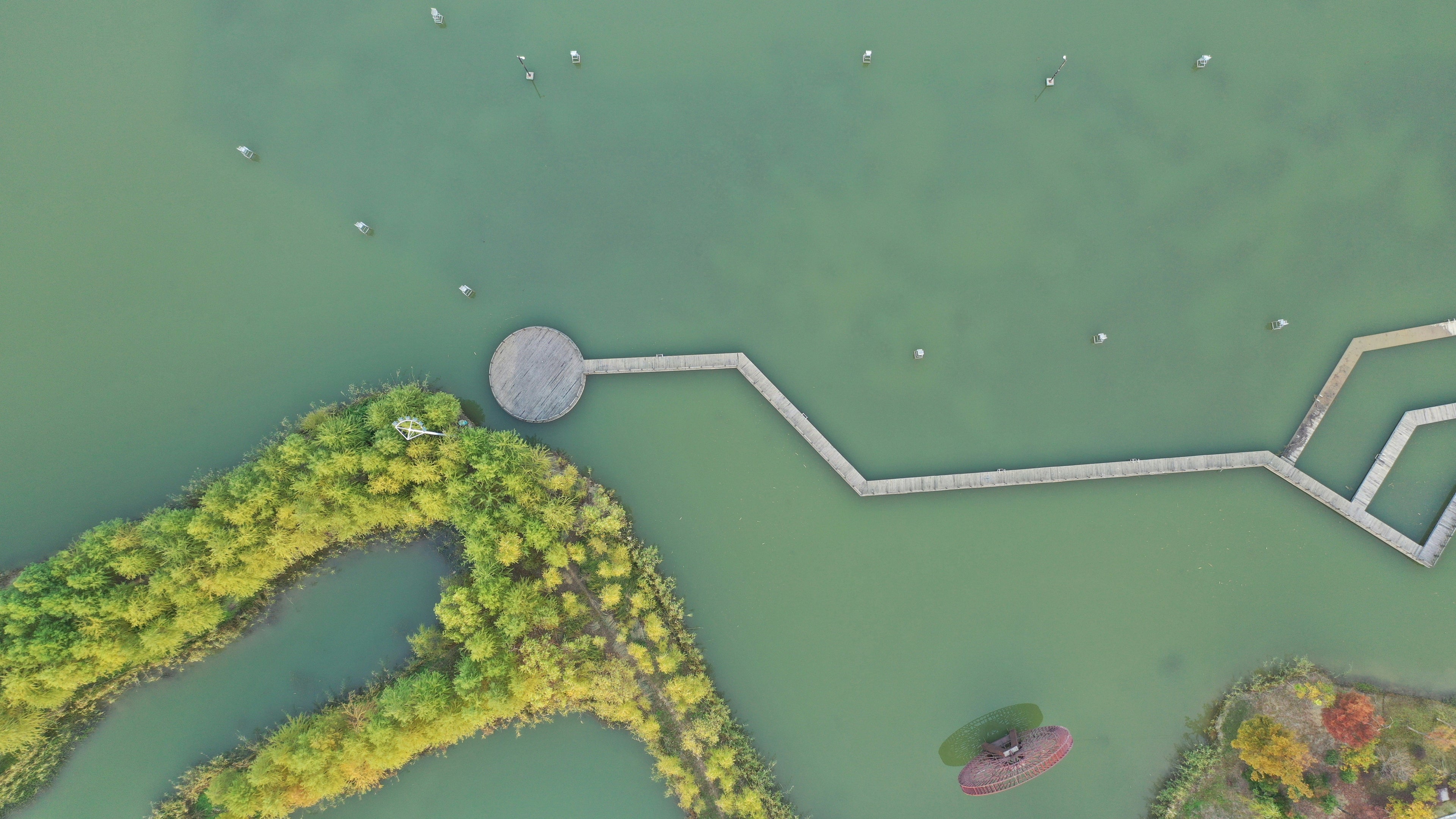 Aerial view of water, tree-covered wetland islands and a zigzag boardwalk at Taihu Wetland Park in Suzhou.