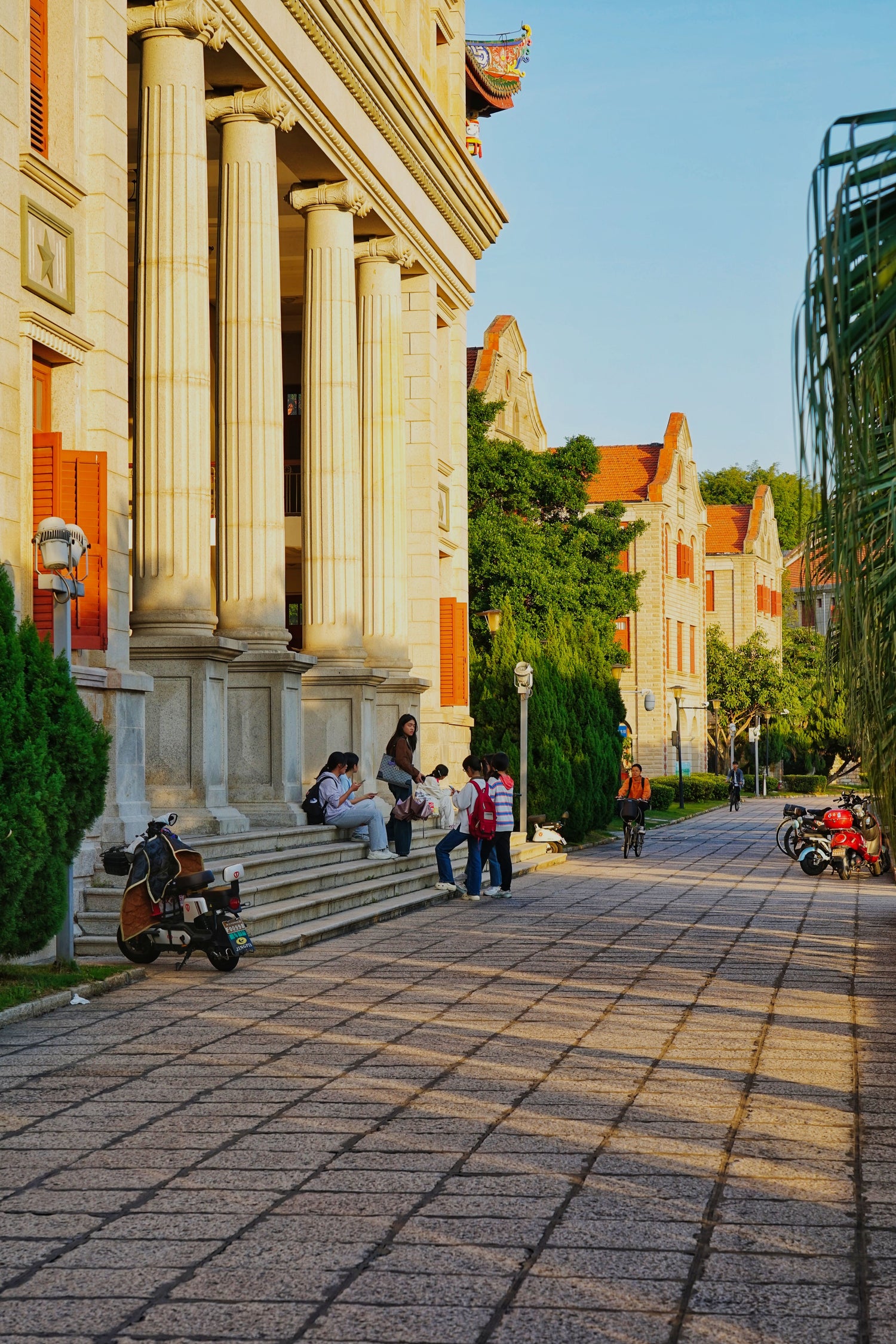 Students gathering outside classical buildings on a university campus in China.