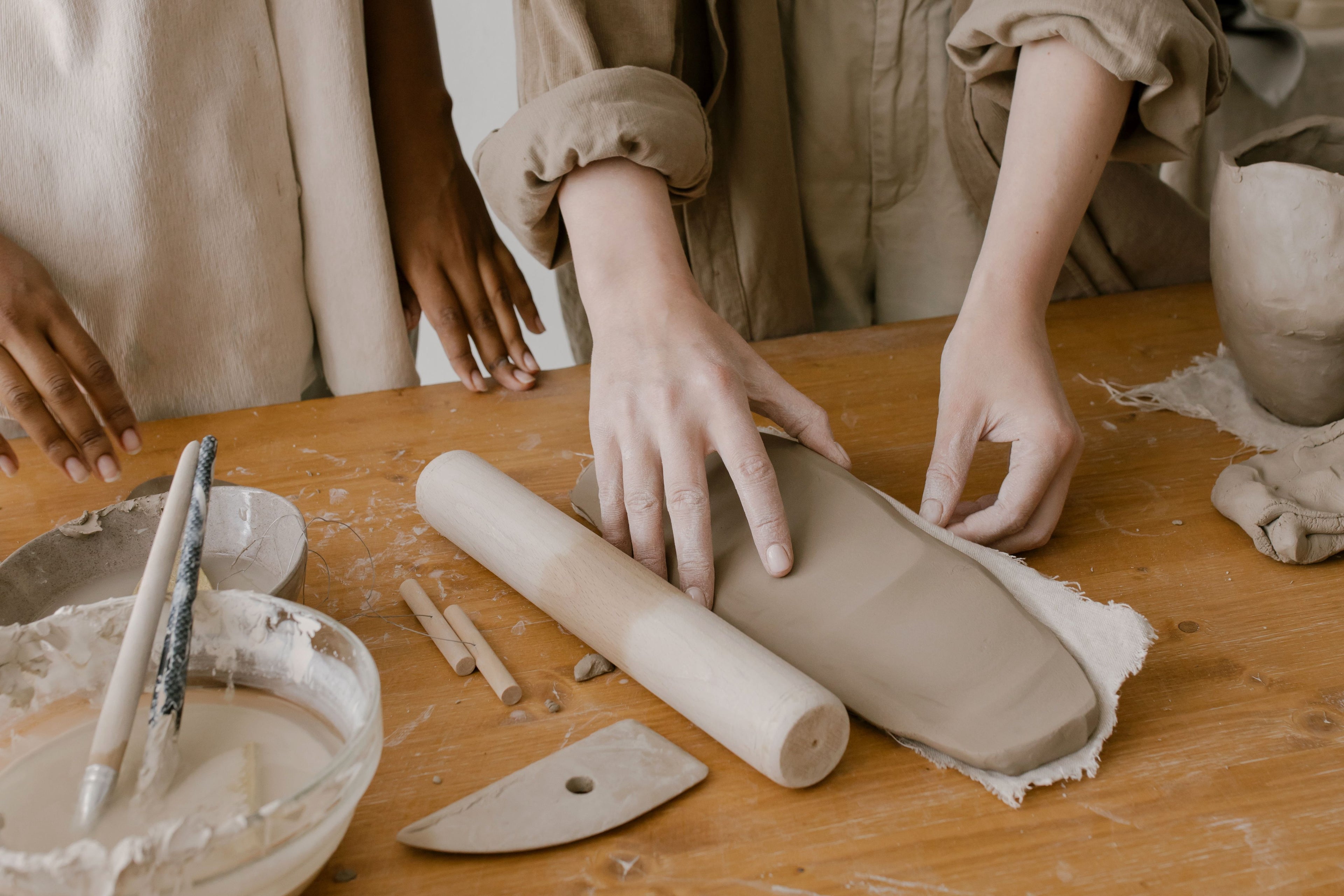 Participants shaping clay together during a hands-on workshop.