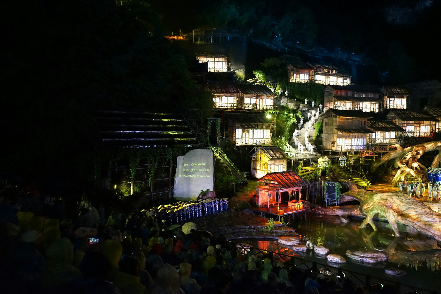 Visitors watching an illuminated night performance in Zhangjiajie.