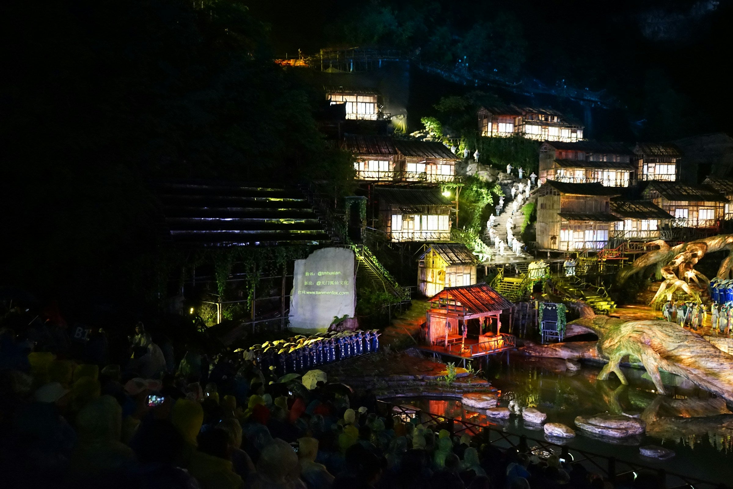 Visitors watching an illuminated night performance in Zhangjiajie.