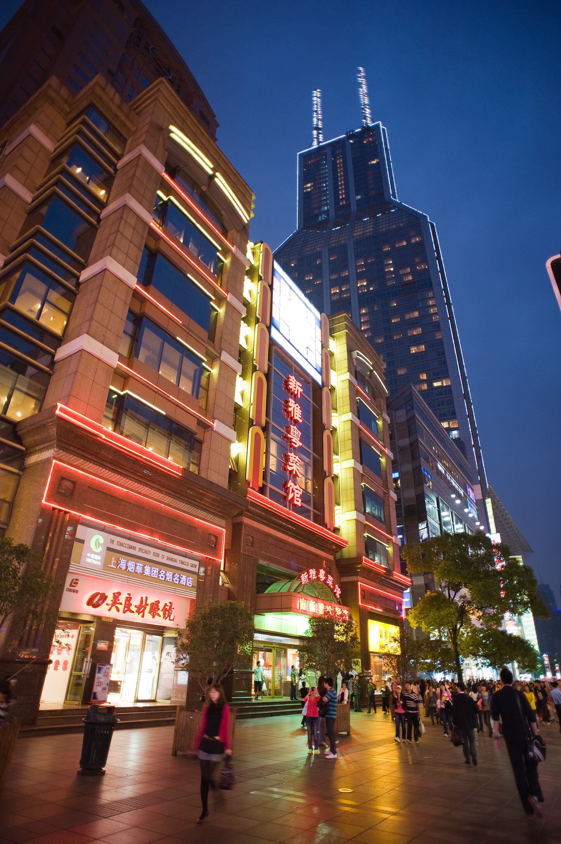 Restaurant frontage, diners and passers-by on a Shanghai street after dark