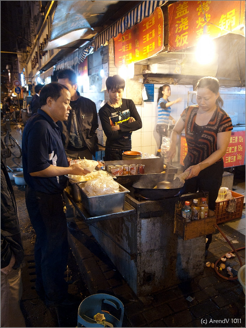 Customers and a cook sharing a late-night Shanghai street-food moment
