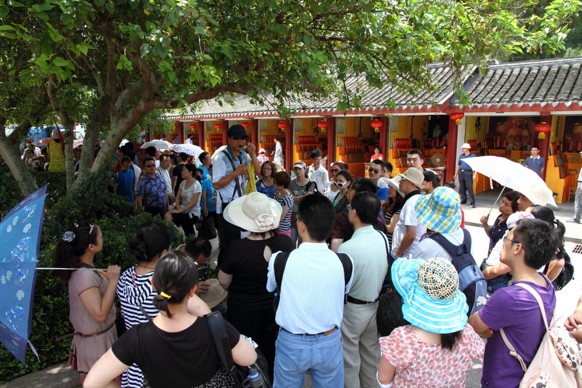A local tour guide addressing visitors at Mount Putuo in China